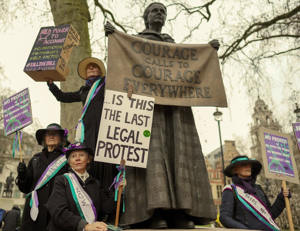 Protesters dressed as suffragettes holding placards including &lsquo;Is this the last legal protest&rsquo; beneath the Millicent Fawcett statue in Parliament Square