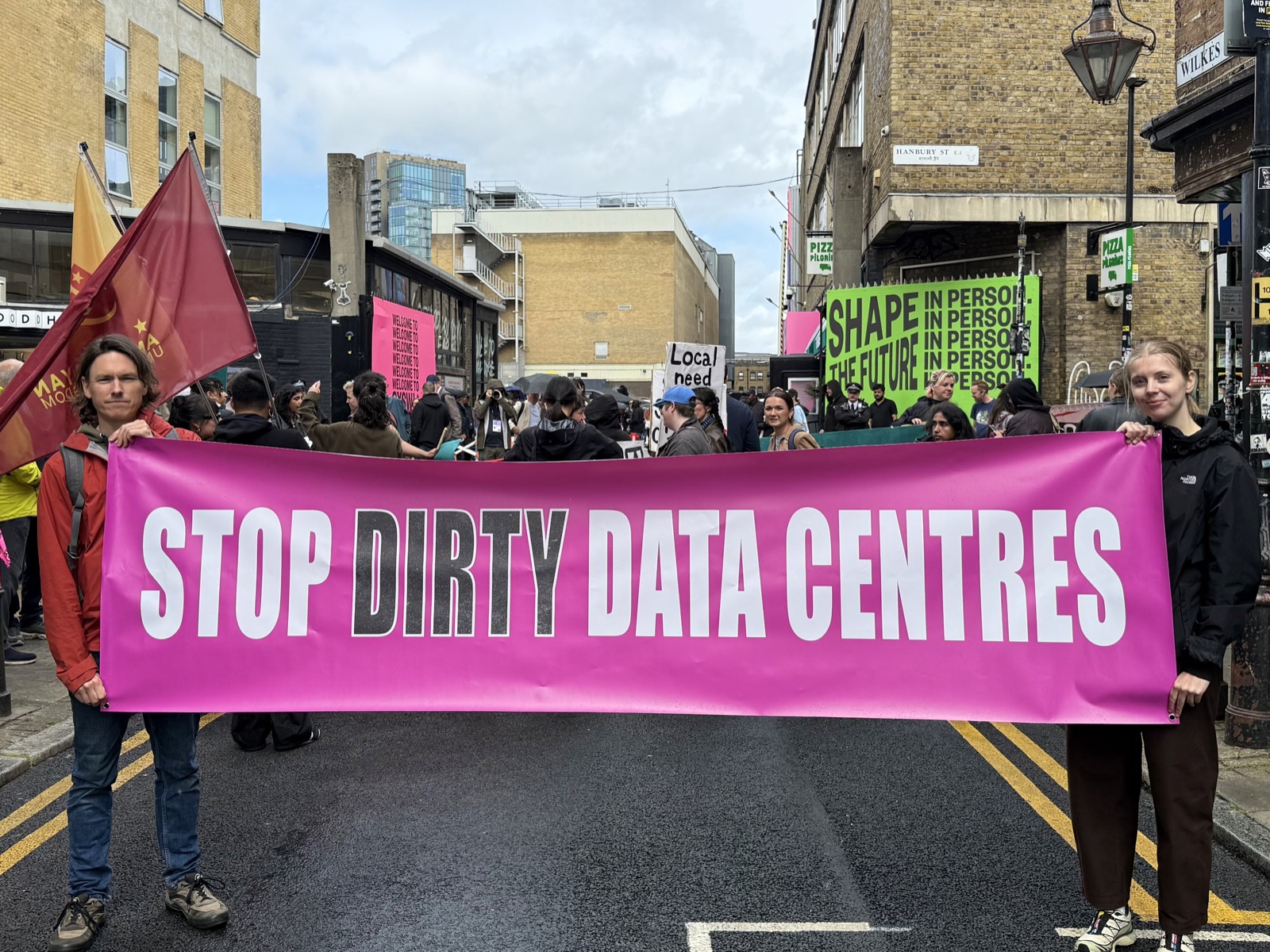 Protesters holding a large pink banner reading "Stop Dirty Data Centres" at a march